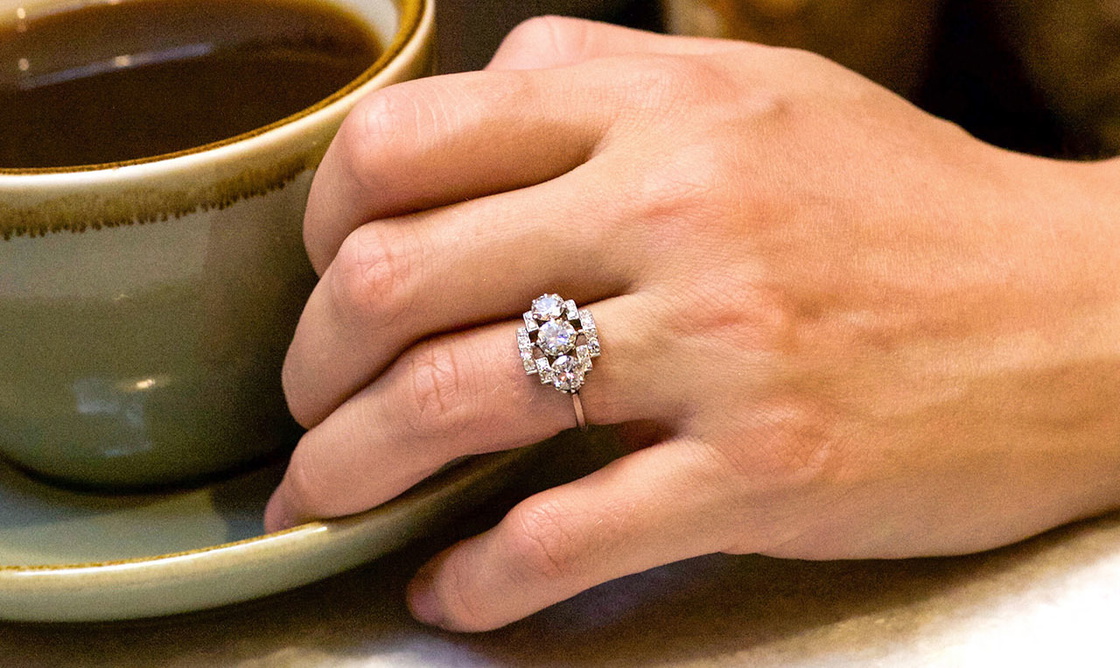 Art Deco Platinum & Three Stone Diamond Ring Within a Geometric Setting