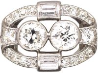 Art Deco Platinum Two Stone Diamond Ring with an Oval Surround of Baguette & Round Diamonds