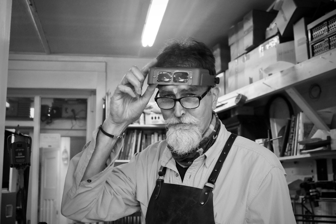 A jeweller with magnifying glasses at the bench