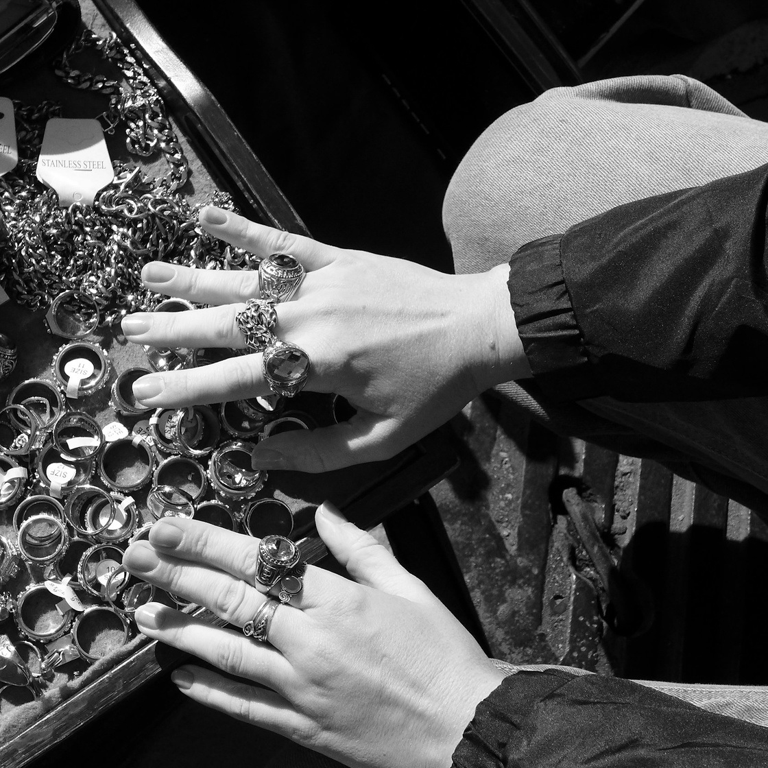 Hands wearing several ornate rings