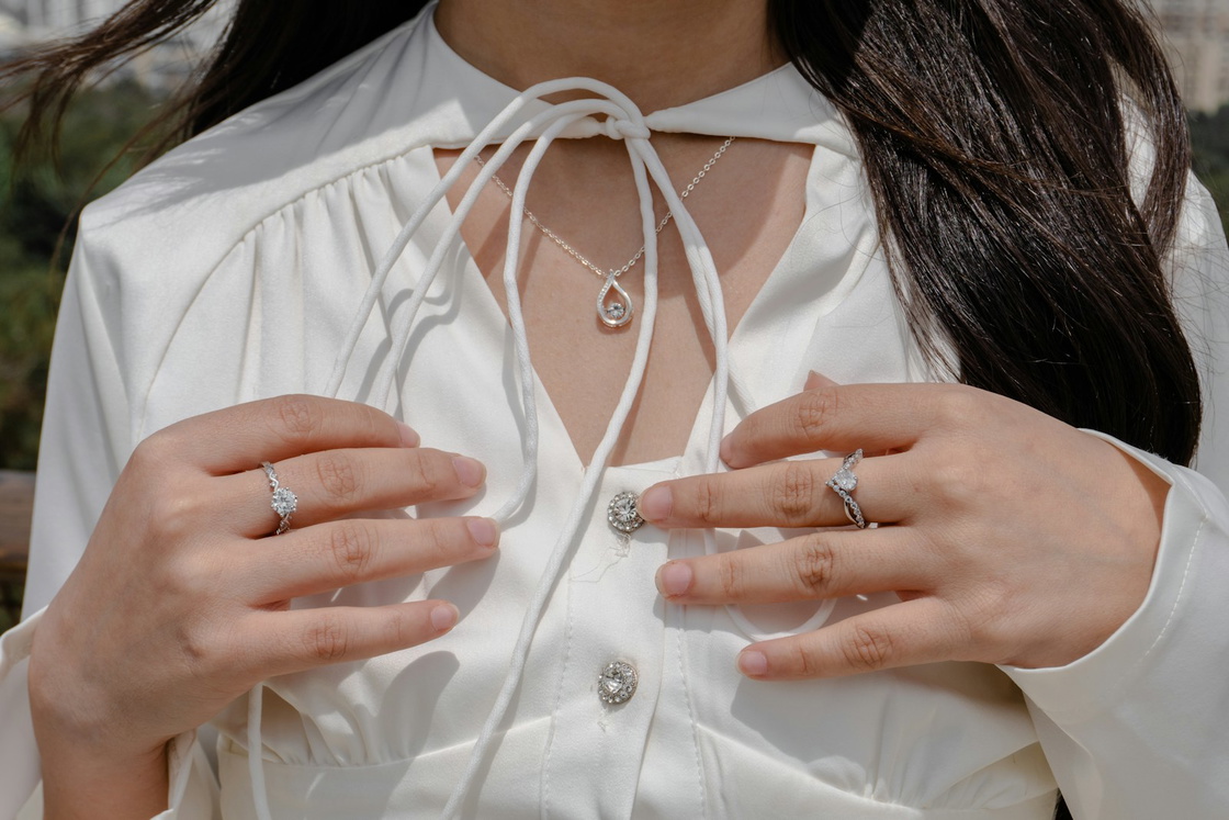 A crisp white blouse with a pendant and rings